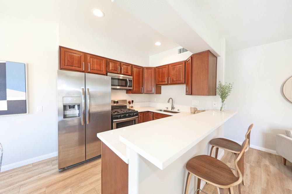 An island and stainless-steel appliances in a kitchen at Pacific Breeze Townhomes in Huntington Beach, California