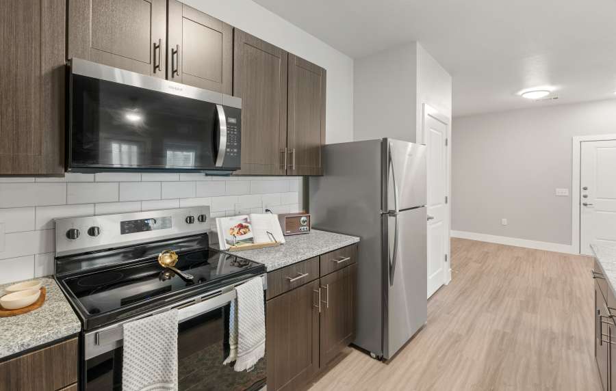 Open kitchen with black appliances at The Janson in Del Valle, Texas 