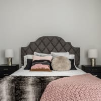 Modern furnishings in a model apartment's primary bedroom at The MK in Indianapolis, Indiana