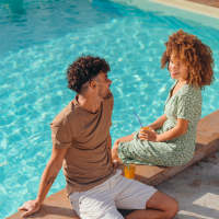 Couple relaxing by sparkling pool at 81 West Apartments in Fort Myers, Florida
