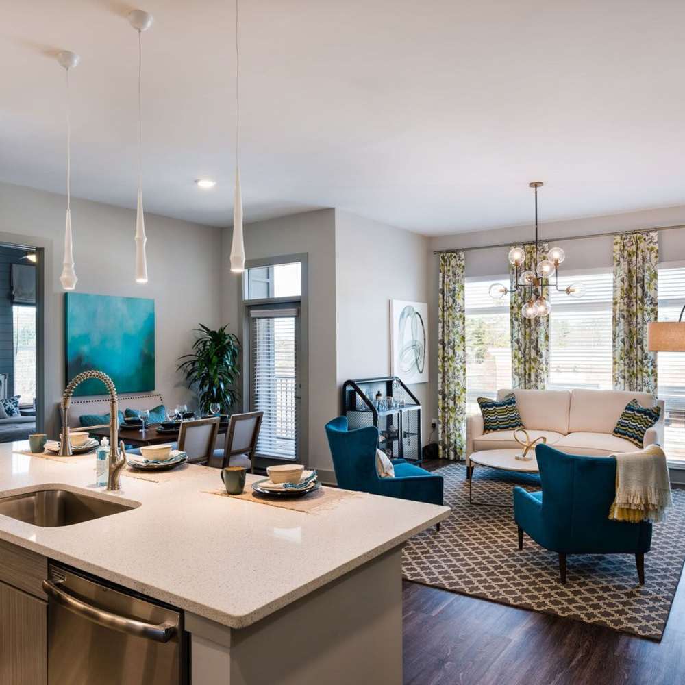 Bright kitchen with dishwasher and living room at Siena Suwanee Town Center in Suwanee, Georgia