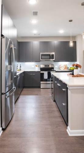 Apartment kitchen with wood-style flooring at Clear Creek Crossing in Wheat Ridge,Colorado