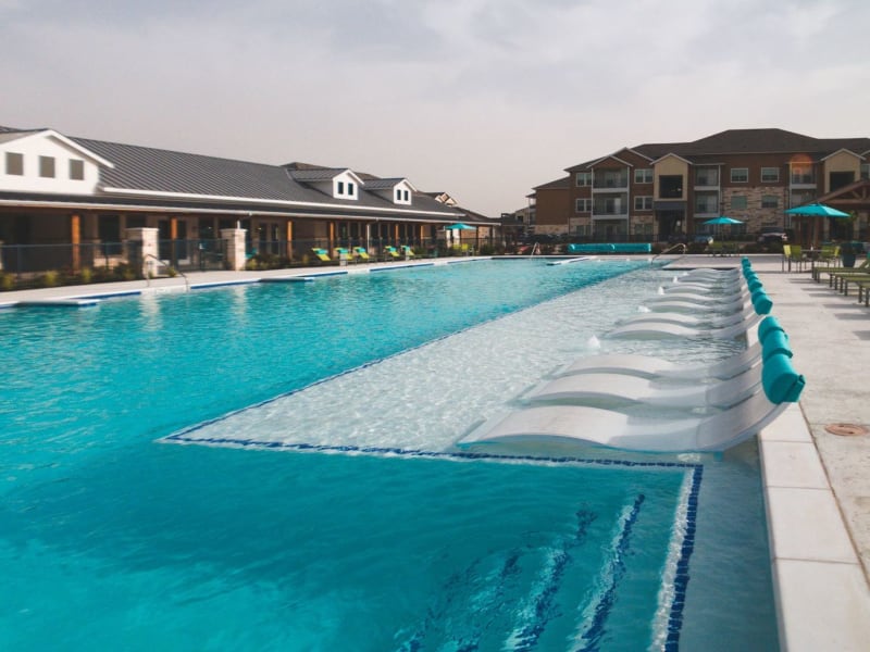 Sparkling swimming pool with expansive sundeck at Biltmore at the Park in Pflugerville, Texas