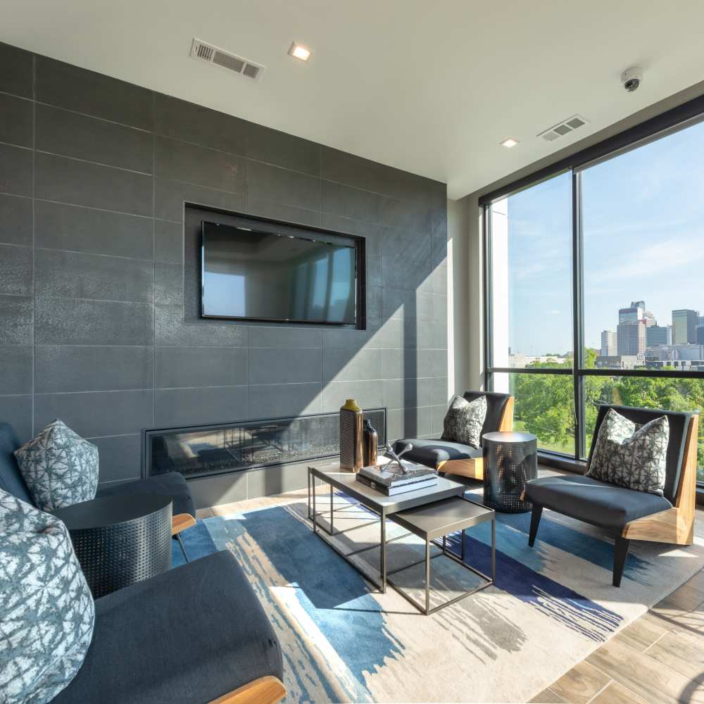 Lounge area with wall-mounted Tv and comfy chairs at Hall Street Flats in Dallas, Texas