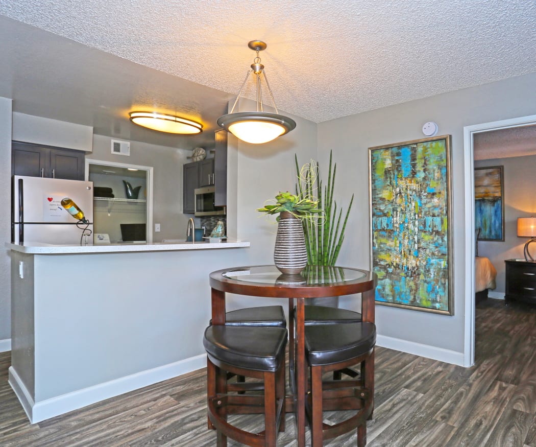 Open-concept floor plan with hardwood-style floors and custom lighting in a model home at Solis at Flamingo in Las Vegas, Nevada