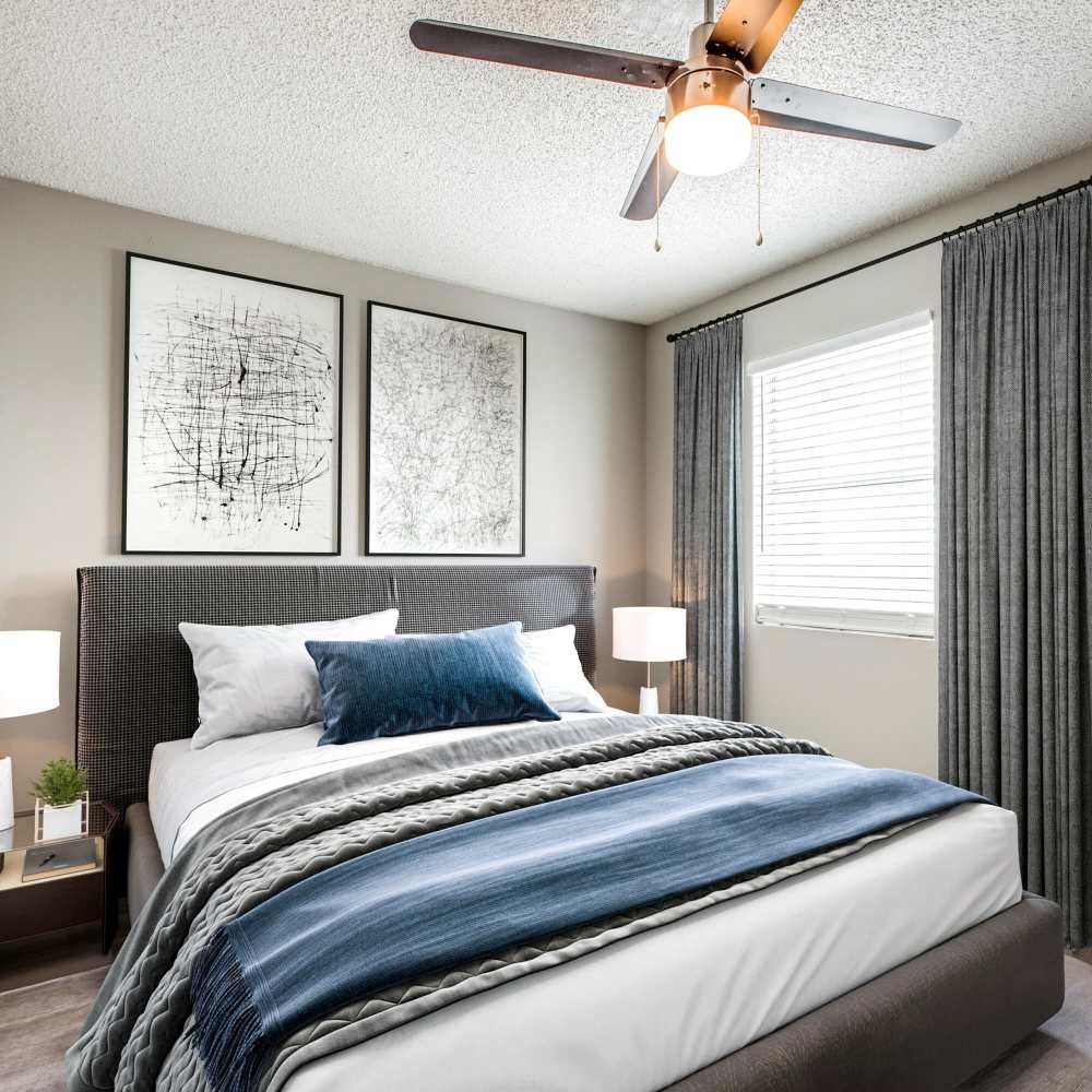 Specious bedroom with large window and ceiling fan at Villa De Oro in San Antonio, Texas
