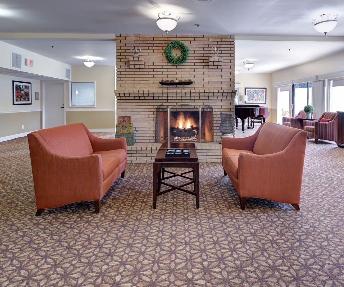 Lounge area with couches and fireplace at Pacifica Senior Living Encinitas in Encinitas, California