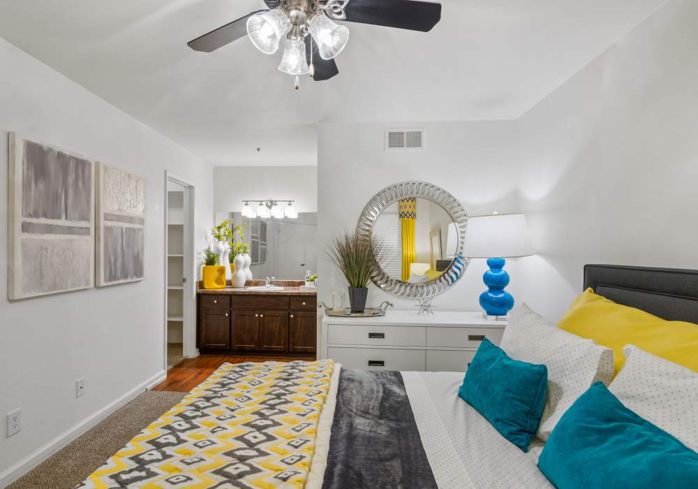 Modern bedroom with ceiling fan and wooden cabinets at Cabrillo Apartments in Scottsdale, Arizona