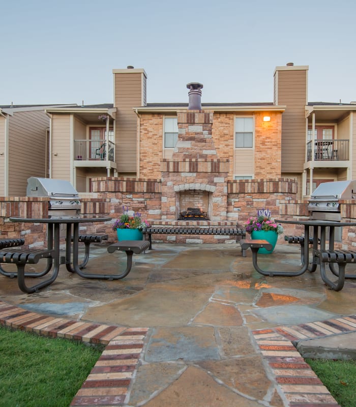 Outside fireplace and benches of Cimarron Trails Apartments in Norman, Oklahoma