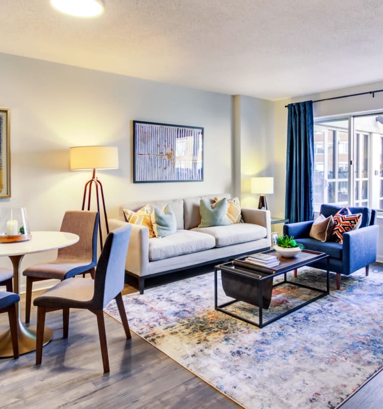 Naturally lit living room with large bay windows in a model home's living area at Sofi at 50 Forest in Stamford, Connecticut