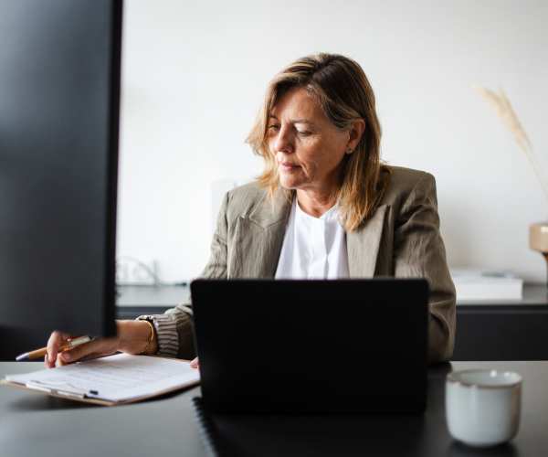 Resident in front of the computer reading in her office at CLS Living in Austin, Texas