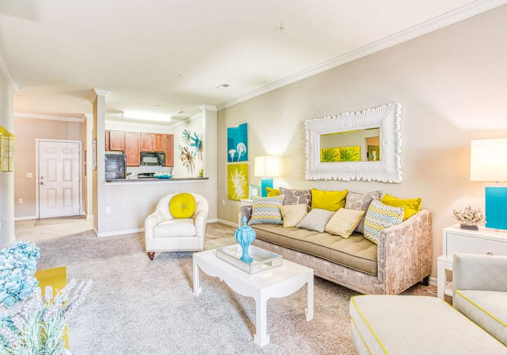 Spacious living room with couch, coffee table, and plush carpeting at Kilnsea Village in Summerville, South Carolina