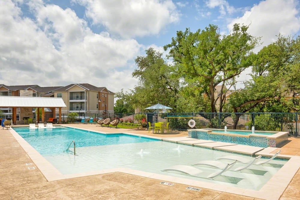 Resort style pool and sundeck lounge seating at Creekside at Kenney's Fort in Round Rock, Texas