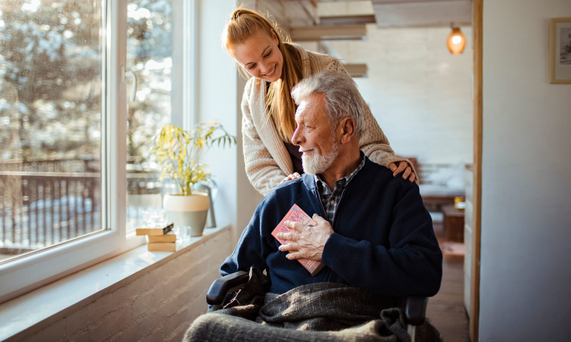 A woman helps a man in a wheelchair at Broadwell Senior Living in Plymouth, Minnesota