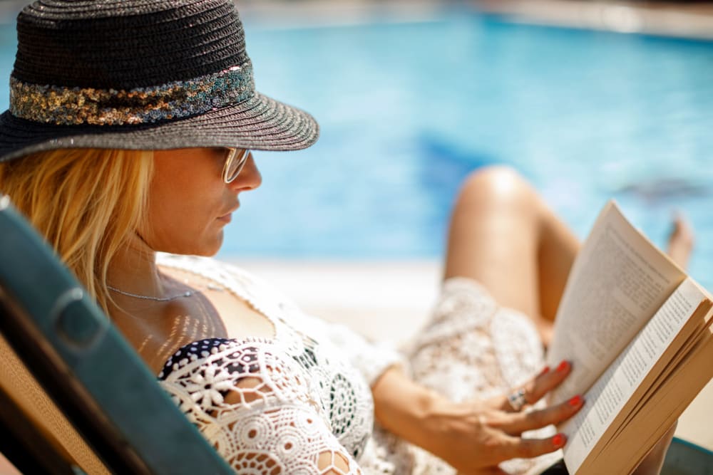 A resident reading by the pool at Enclave at Woodcrest Station in Cherry Hill, New Jersey