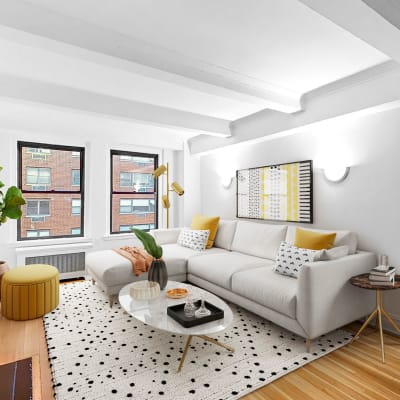 Spacious living room with a large panel windows at The Sutton Collection in New York, New York