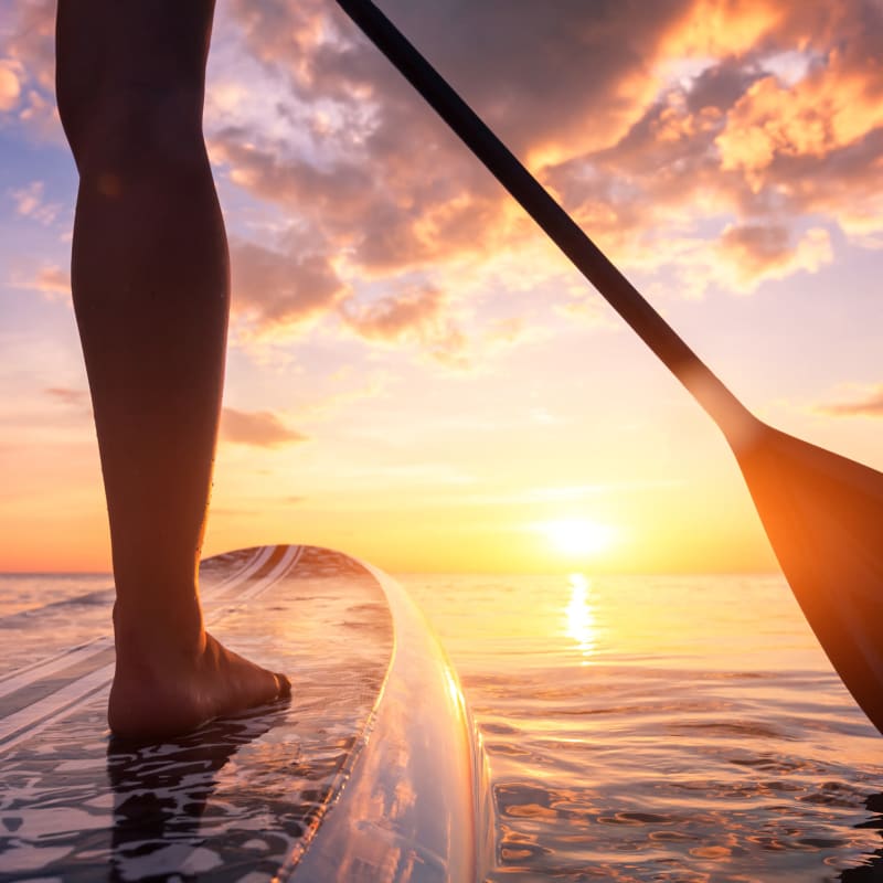 Woman paddleboarding at sunset at Portside Ventura Harbor in Ventura, California