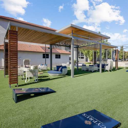 Outdoor seating area with corn hole board at Cyprus in Phoenix, Arizona