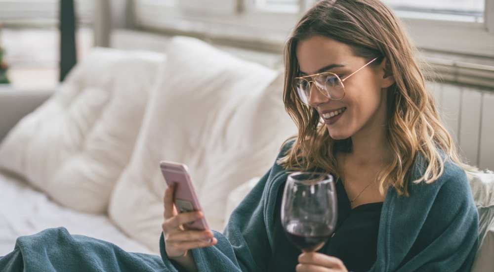 Resident woman enjoying wine in a model home's living space at Grandview South Homes in Pittsburgh, Pennsylvania