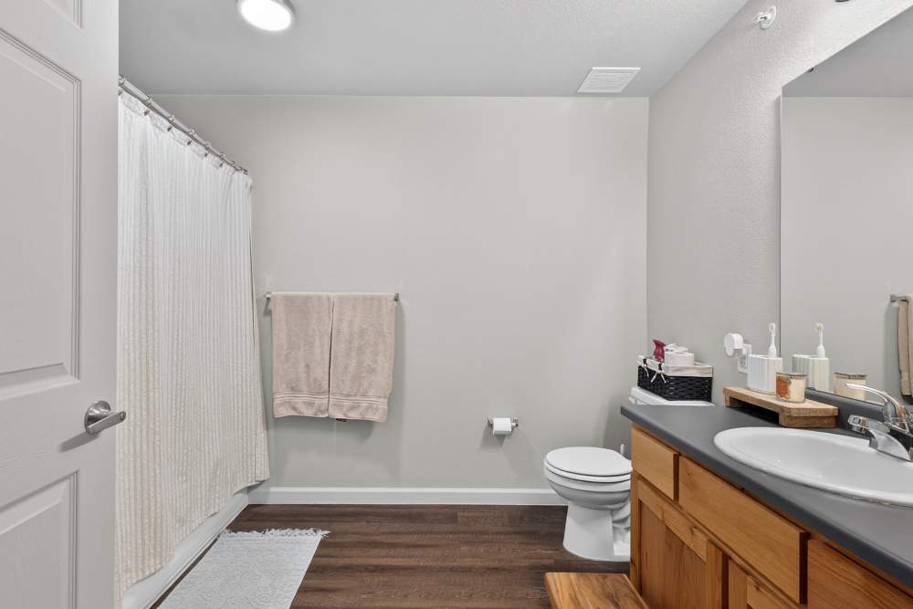 Bright and inviting bathroom with warm wooden accents and modern fixtures at Lakewood Crossing in Granbury, Texas.