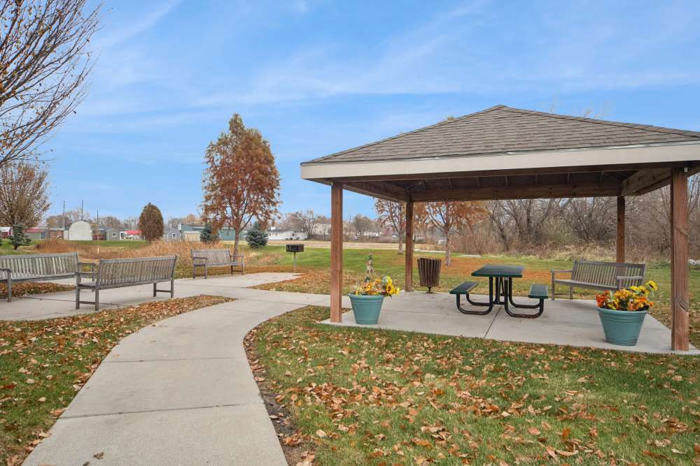 Charming picnic area with a gazebo and landscaped seating options at Villas At Meadow Springs in Ankeny, Iowa