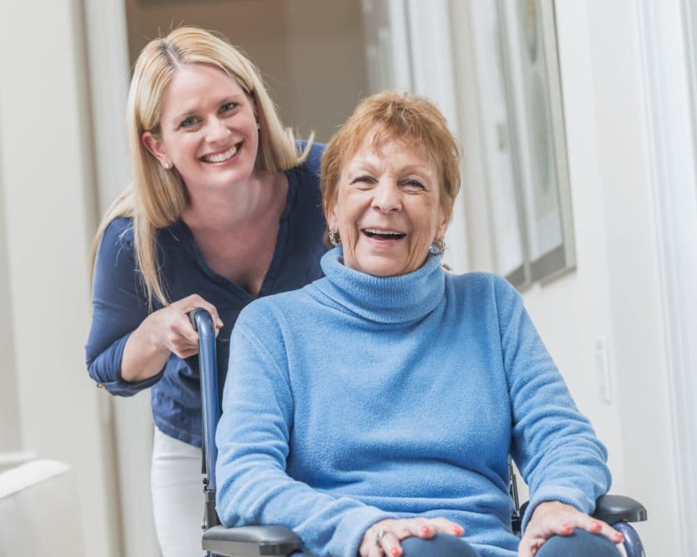 Resident being pushed in her wheelchair at Courtyard Estates at Cedar Pointe in Pleasant Hill, Iowa.
