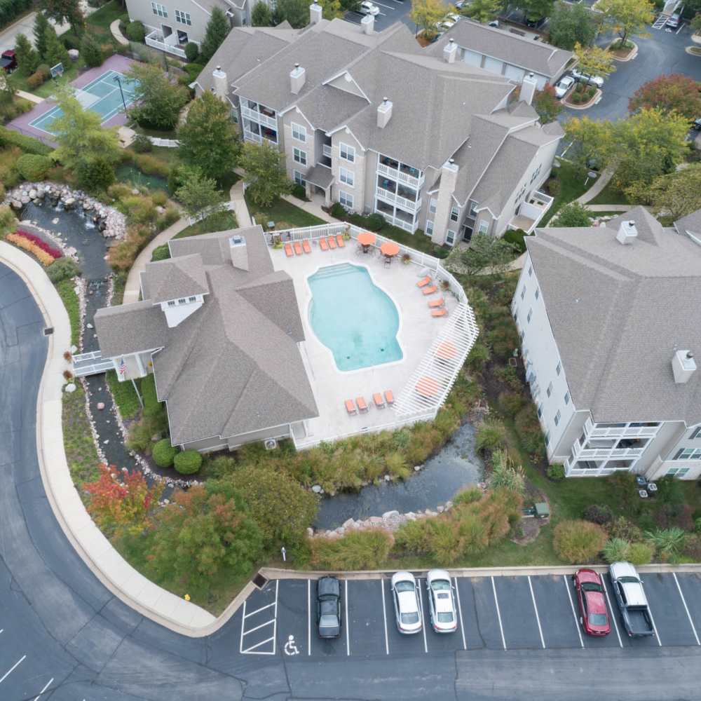 A serene oasis featuring a sparkling water pool, lush landscaping, and charming amenities at Boulder Springs in Maryland Heights, Missouri.