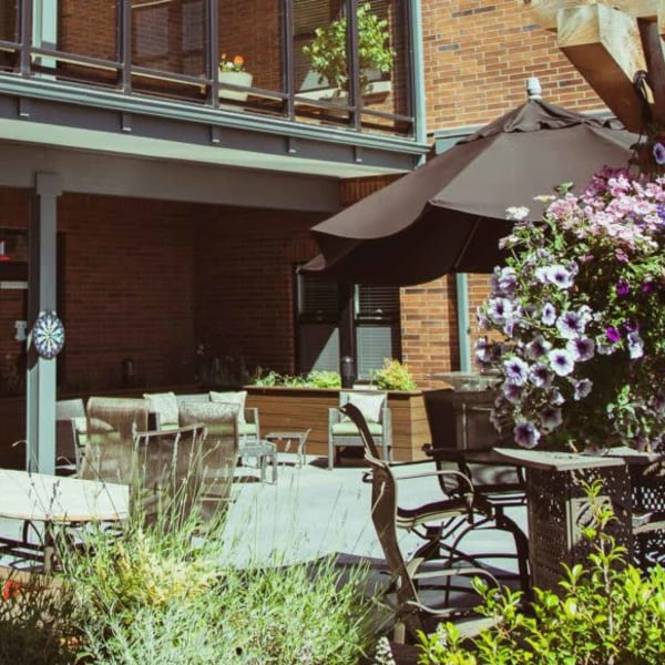 Patio with shaded seating at Quail Park Memory Care Residences of West Seattle in Seattle, Washington
