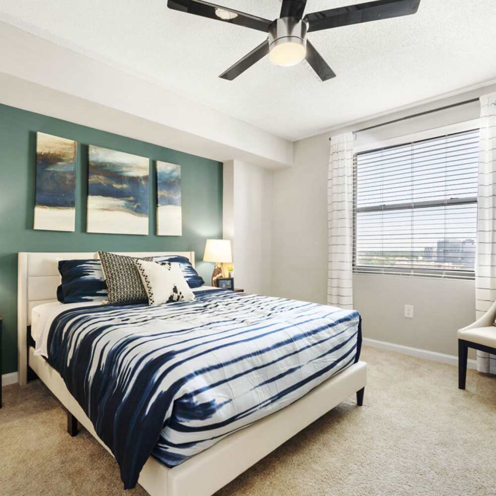Bright bedroom with large bed and ceiling fan at The Eva in Sandy Springs, Georgia