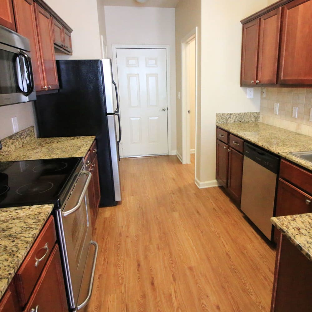 Stainless-steel appliances and granite countertops in a townhome's kitchen at Oaks Estates of Coppell in Coppell, Texas