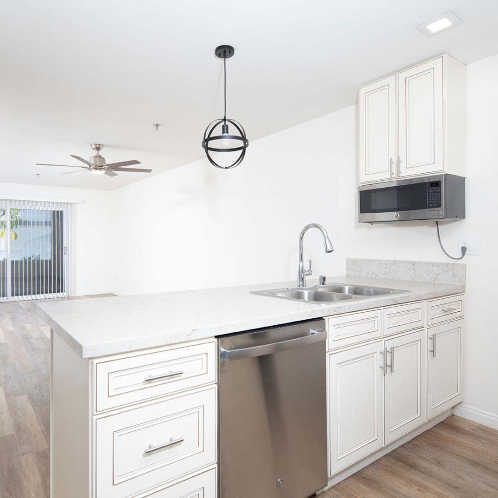 Kitchen with black appliances and white cabinetry at Hillcrest Summit in San Diego, California