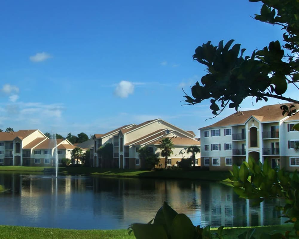 Exterior view with water and grassy area at San Marco Apartments in Ormond Beach, Florida