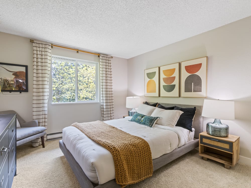 Spacious and move-in ready bedroom with carpet and forest view at Haven Apartment Homes in Kent, Washington