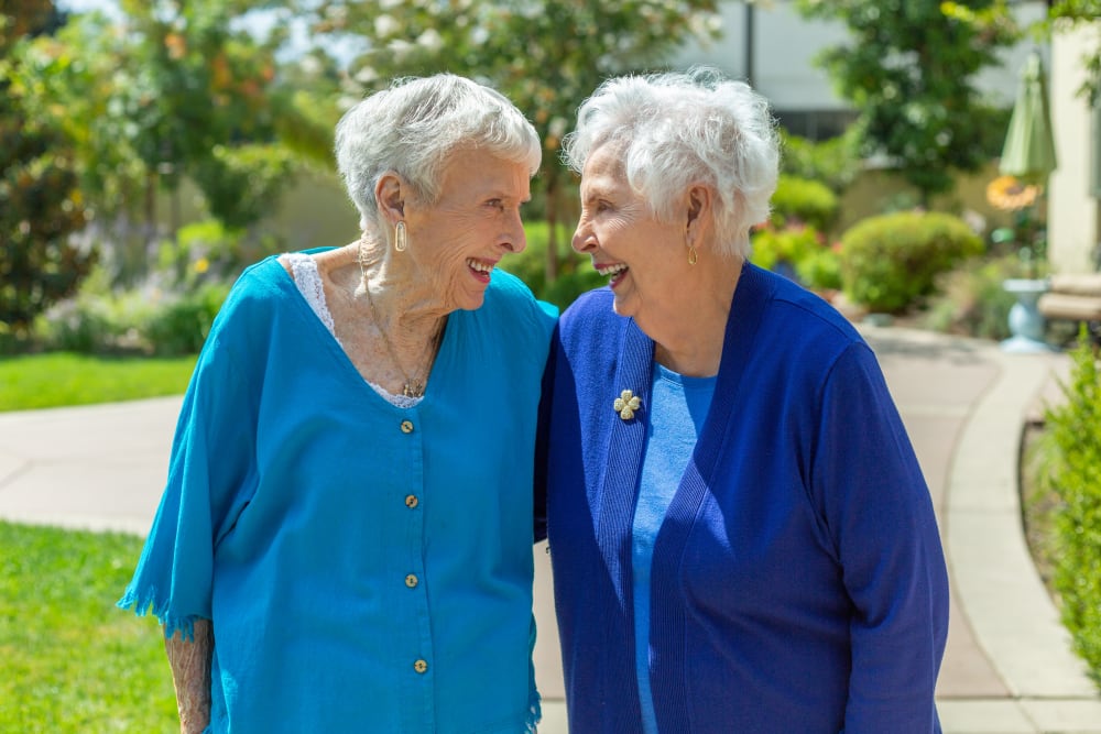 Two women walking and laughing at Merrill Gardens at Hillsboro in Hillsboro, Oregon. 