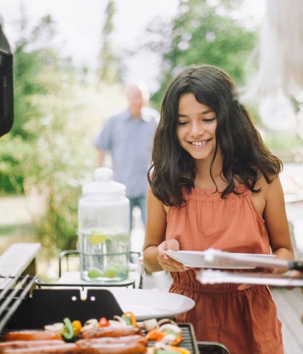 young girl getting dinner from the bbq at The Boulders at Fountaingrove in Santa Rosa, California