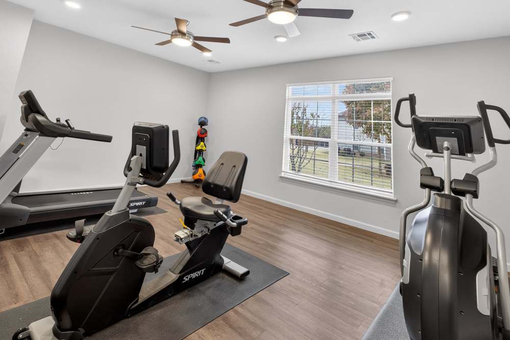 Modern fitness room filled with high-quality equipment and natural light at Lakewood Crossing in Granbury, Texas.