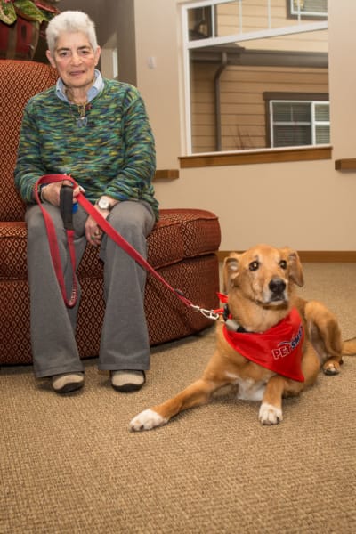 Female resident sitting with her dog at Quail Park of Lynnwood in Lynnwood, Washington