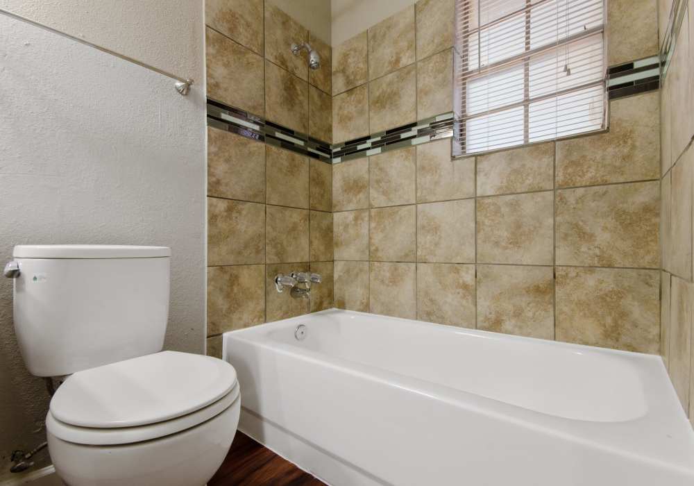 Bathroom with bath tub and commode at 1000 Mary Apartment Homes in Iowa Park,Texas