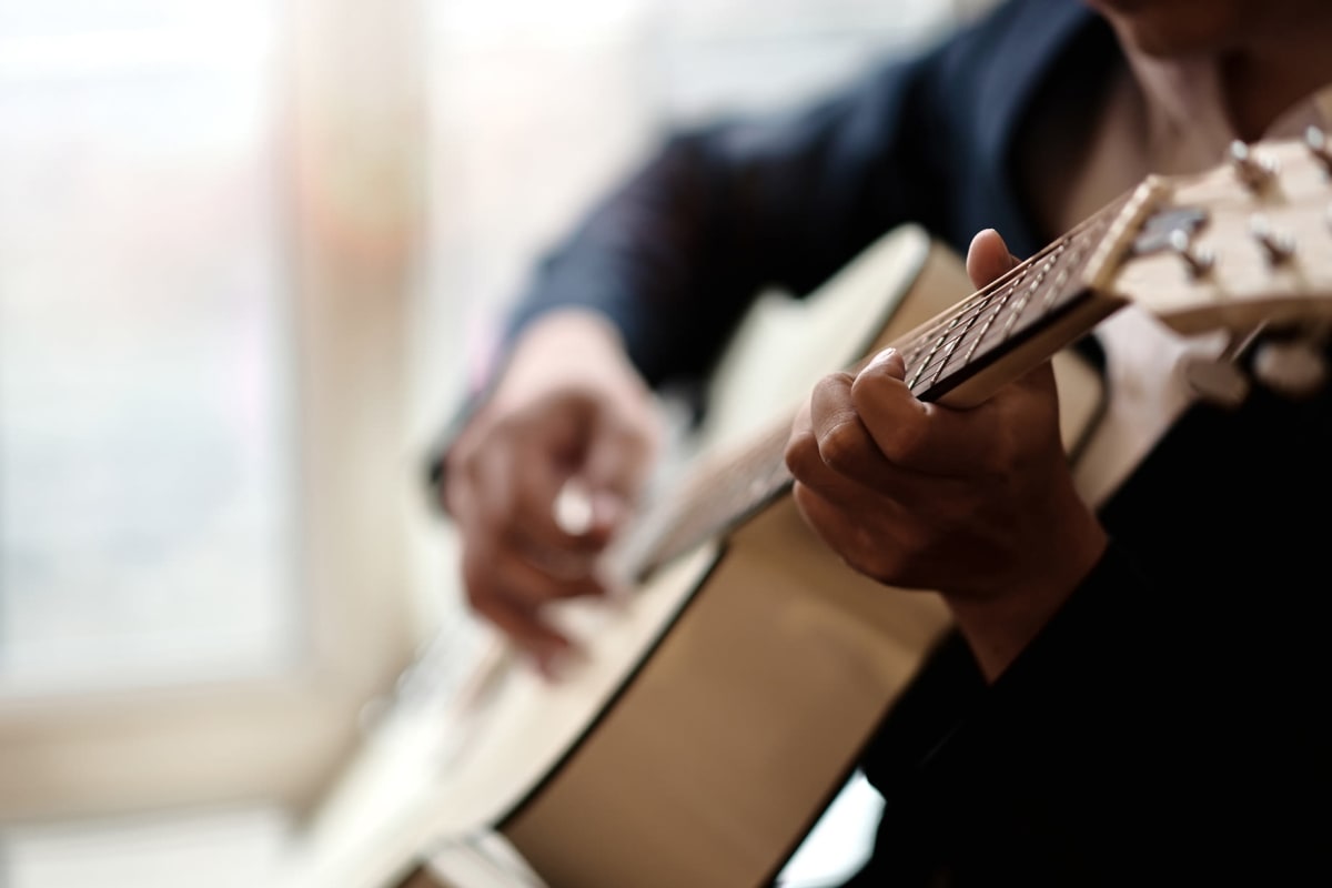 Resident playing guitar at Monark Grove Clarkston in Clarkston, Michigan