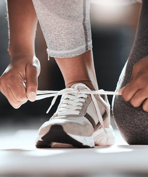 Resident tying their shoe at the fitness center at Silvermine in Victoria, Texas