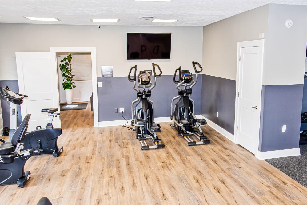 A fitness center with spin bikes and a flat-screen TV at Silver Lake Hills in Fenton, Michigan
