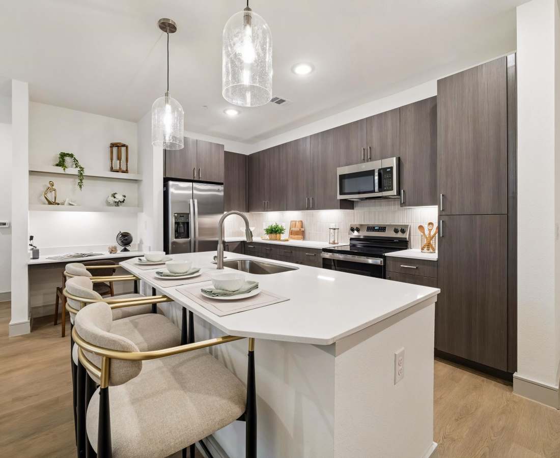 Luxury kitchen island with seating and modern appliances at Dakota at Hillcroft in Houston, Texas