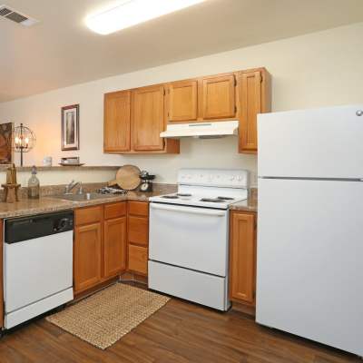 Apartment kitchen with wooden cabinets at Woodforest Chase in Houston, Texas