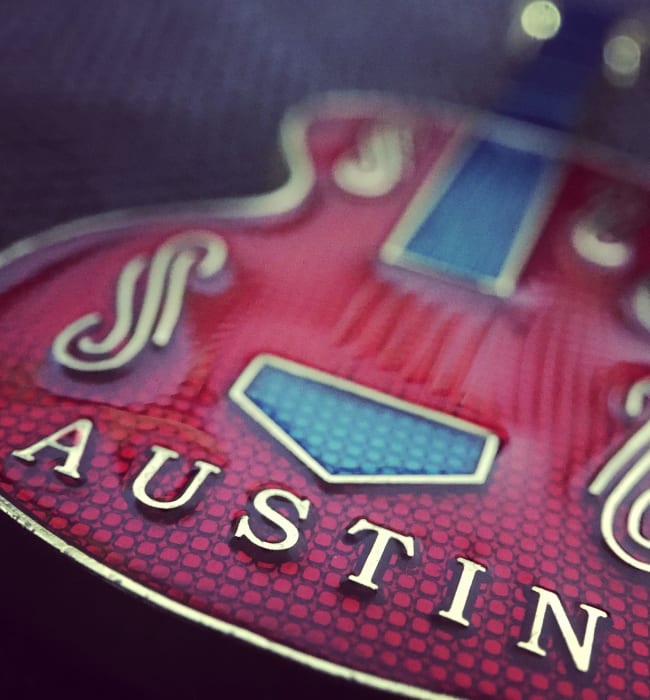 Burgundy Blues electric guitar with Austin lettering on body near Marq on Burnet in Austin, Texas