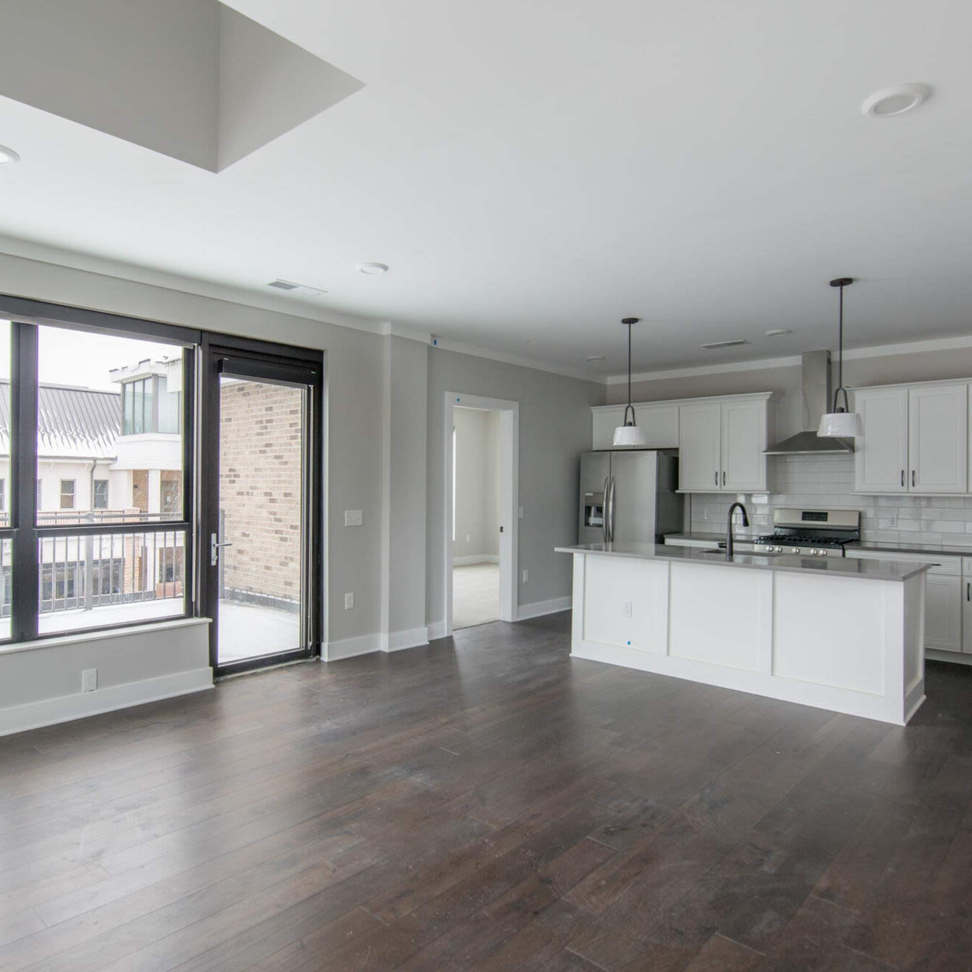 Open-plan living area with modern kitchen and balcony at Bridge Park in Dublin, Ohio