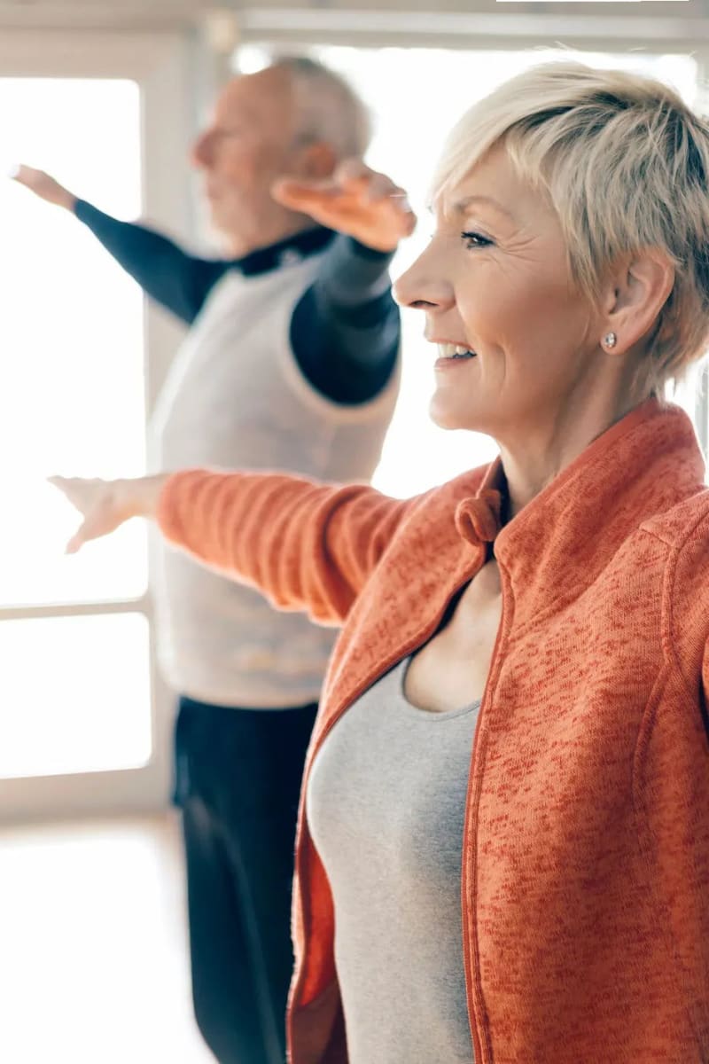Resident couple doing yoga at Carriage Inn Huntsville in Huntsville, Texas