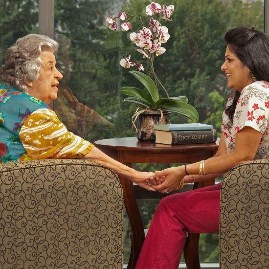 Resident and staff member holding hands at Madonna Gardens in Salinas, California