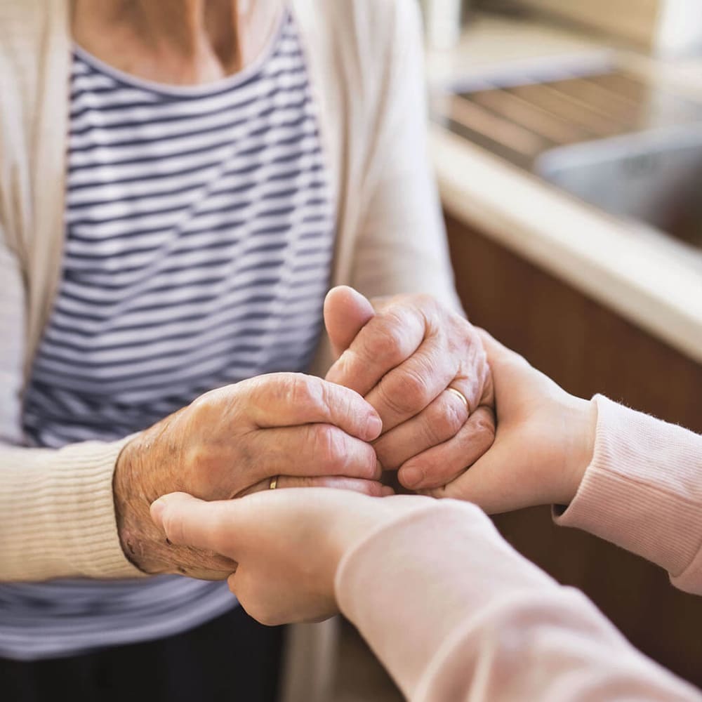 Resident holding hands with a caretaker at Anthology Senior Living in Chicago, Illinois