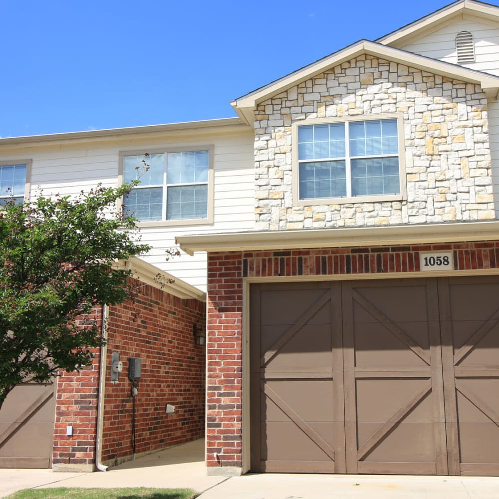 Private garage next to a townhome's entrance at Oaks Estates of Coppell in Coppell, Texas