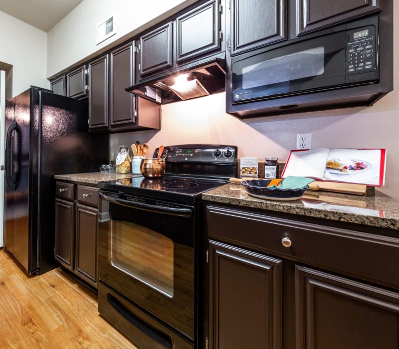 Kitchen with black appliances at Marquis on Pin Oak in Houston, Texas